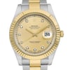An image of a pre-owned Rolex Oyster Perpetual Datejust men's wristwatch in good condition. The watch is presented in a front close-up view, with the face centered and occupying most of the frame. It features a round champagne dial with diamond markers at each hour and a date indicator at the 3 o'clock position. The bezel is gold with a fluted design, and the band is made of a combination of stainless steel and yellow gold. The Rolex logo is visible at the 12 o'clock position, and the watch hands are in a neutral position. Signs of minor wear are visible upon close inspection.