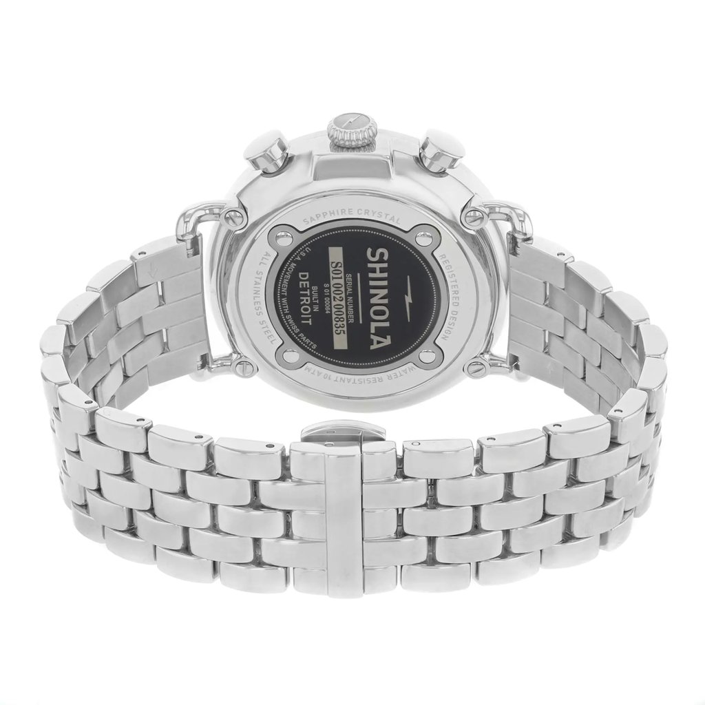 An image of a pre-owned wristwatch showcasing the back view. The focus is on the closed clasp and the watch's stainless steel band, positioned centrally. The angle is straight on, capturing the details of the watch's back case and the branding clearly. The distance is close enough to highlight the textures and inscriptions on the watch.