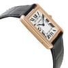 An image of a pre-owned Cartier luxury wristwatch for women, showcasing a side profile view opposite of the crown. The watch is captured at a close distance, angled to display its silver dial and rectangular rose gold case, which shows minor signs of wear. It features a black leather band and a rose gold bezel.