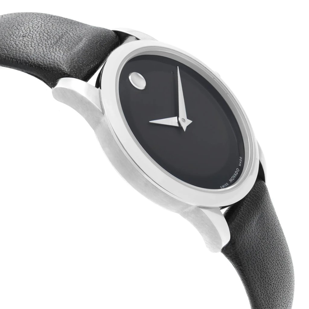 An image of a pre-owned wristwatch shown from a side profile view, opposite of the crown. The watch face is angled slightly upward, showcasing its sleek, minimalist design with a black dial and silver hands. The leather strap is visible, emphasizing its textured surface. The watch is positioned close enough to highlight the details of the case and band.