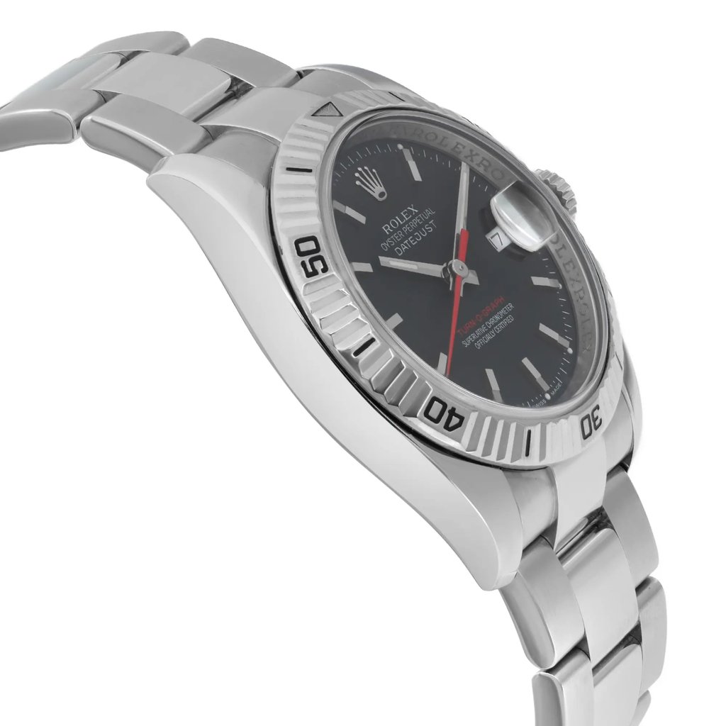 An image of a pre-owned wristwatch viewed from the side profile opposite the crown. The watch features a stainless steel band and a dark dial with white hour markers. The bezel has embossed numbers and the overall angle of the shot showcases the thickness and design of the watch case, highlighting its sleek and polished finish. The photograph is taken at a close distance, offering a detailed view of the watch's craftsmanship.