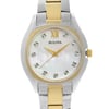 An image of a pre-owned Bulova women's wristwatch in a dress/formal style, featuring a close-up front view of the watch face at a straight angle. The watch has a distinctive tonneau/barrel shape with a mother of pearl dial that has a subtle iridescent pattern, complemented by gold-tone Roman numeral indices at the 12 o'clock position and non-numeric hour marks. The bezel color is gold-tone, contrasting with the stainless steel case and the two-tone stainless steel band that combines silver and gold elements. A seconds hand is visible on the dial, and the Bulova logo is prominently displayed below the 12 o'clock mark. The watch is positioned against a neutral background, highlighting its elegant design and fine details.