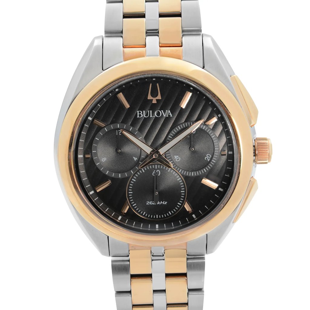 An image of a pre-owned Bulova men's wristwatch in a casual and dress/formal style. The photograph is a front close-up shot of the watch face, showing the watch at a direct angle and close distance to capture detail. It features a black dial with non-numeric hour marks, including multi-dials for the chronograph function, and luminous hands. The round case and band are made of stainless steel with gold accents on the bezel and band. The watch also has a 12-hour dial display.