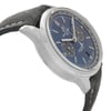 An image of a Breitling men's luxury wristwatch displayed in a side profile view opposite the crown. The watch features a round stainless steel case and a sunburst blue dial with silver-tone markers and hands. The bezel is also steel-colored, and the watch is fitted with a grey leather band positioned at a close distance to provide a clear view of the dial details and side profile of the case. The watch is a display model and has never been worn, there may be minor blemishes on the band due to store handling.