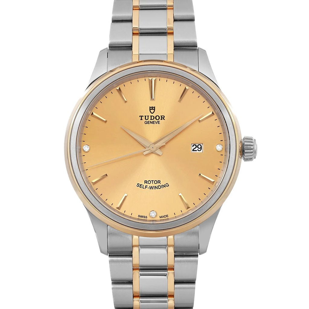 An image of a wristwatch featuring a close-up, front-facing view of the watch face. The watch has a gold-toned dial with slim hour markers and hands, accompanied by a date display at the 3 o'clock position. The case and bracelet are two-toned, combining silver and gold elements. The watch is in unworn condition, highlighting its pristine appearance.