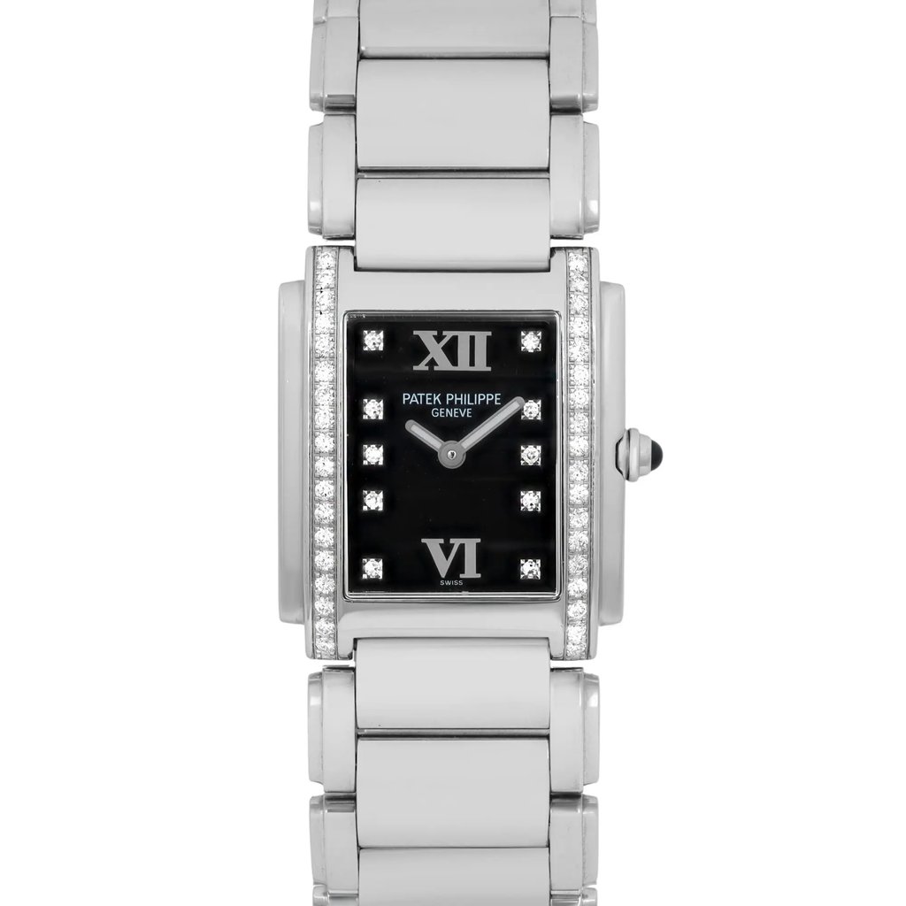 An image of a pre-owned women's Patek Philippe wristwatch, viewed from a straight-on angle at a close distance. The watch features a rectangular black dial with luminous hands and diamond hour markers, framed by a diamond-set bezel. The silver bracelet is prominently displayed, emphasizing the watch's elegant and luxurious design.