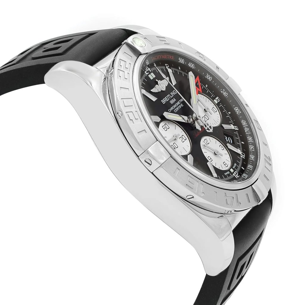 An image of a pre-owned Breitling men's luxury wristwatch, shown in a side profile view opposite the crown. The watch features a black dial with chronograph subdials, a gray bezel with tachymeter markings on the inner bezel ring, and a round stainless steel case. It is fitted with a black rubber band. The image is taken from a close distance, focusing on the side of the watch to emphasize the case thickness and band design.