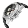 An image of a pre-owned Breitling men's luxury wristwatch, viewed from a side profile highlighting the crown. The watch features a round stainless steel case with a gray bezel, and a black dial, and is fitted with a black rubber band. The crown and pushers are prominently visible, and the watch is positioned at a slight angle to showcase its design, occupying the central portion of the frame. The watch shows minor signs of wear and scratches.