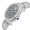 An image of a pre-owned Cartier men's wristwatch taken from a slightly elevated angle, showcasing the right side of the watch. The watch features a silver metal band and case, with a black dial displaying Roman numerals, a date indicator, and luminous hands. The crown is adorned with a blue gemstone. The watch face is in focus, highlighting its elegant design and details.