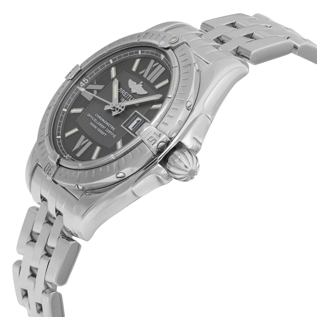 An image of a pre-owned wristwatch shown from a side profile view, highlighting the detailed crown. The watch features a metallic band and a dark face with luminous hour markers. The angle captures the curvature of the case and bracelet, emphasizing the watch's polished finish from a close distance.