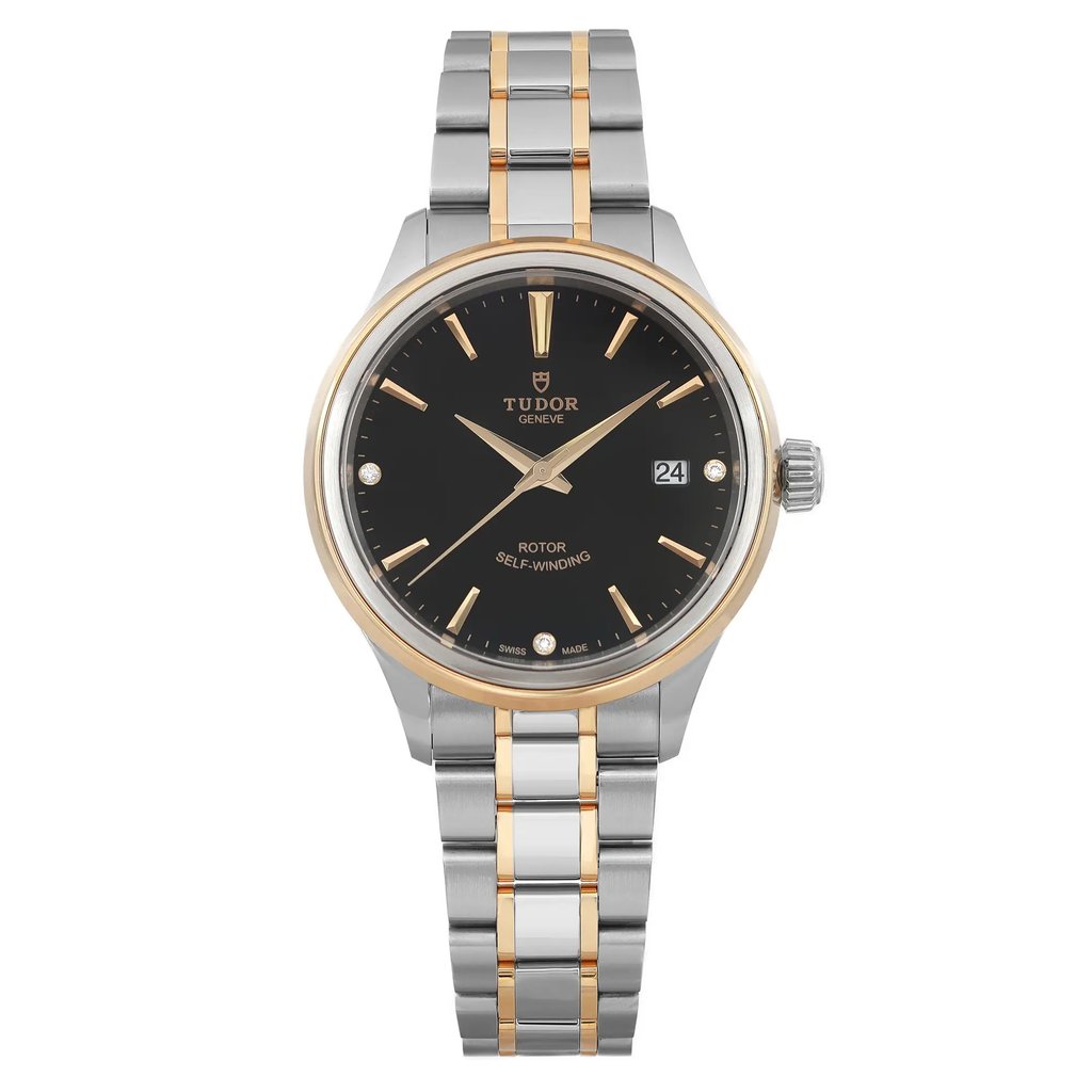 An image of a wristwatch taken from a front full-frontal view. The watch is unworn and features a dual-tone metal bracelet with gold and silver links. The black dial has gold hour markers and hands, with a date display at the 3 o'clock position. The brand name is visible at the top of the dial. The watch is positioned centrally against a plain background, captured at a close distance to highlight its details.