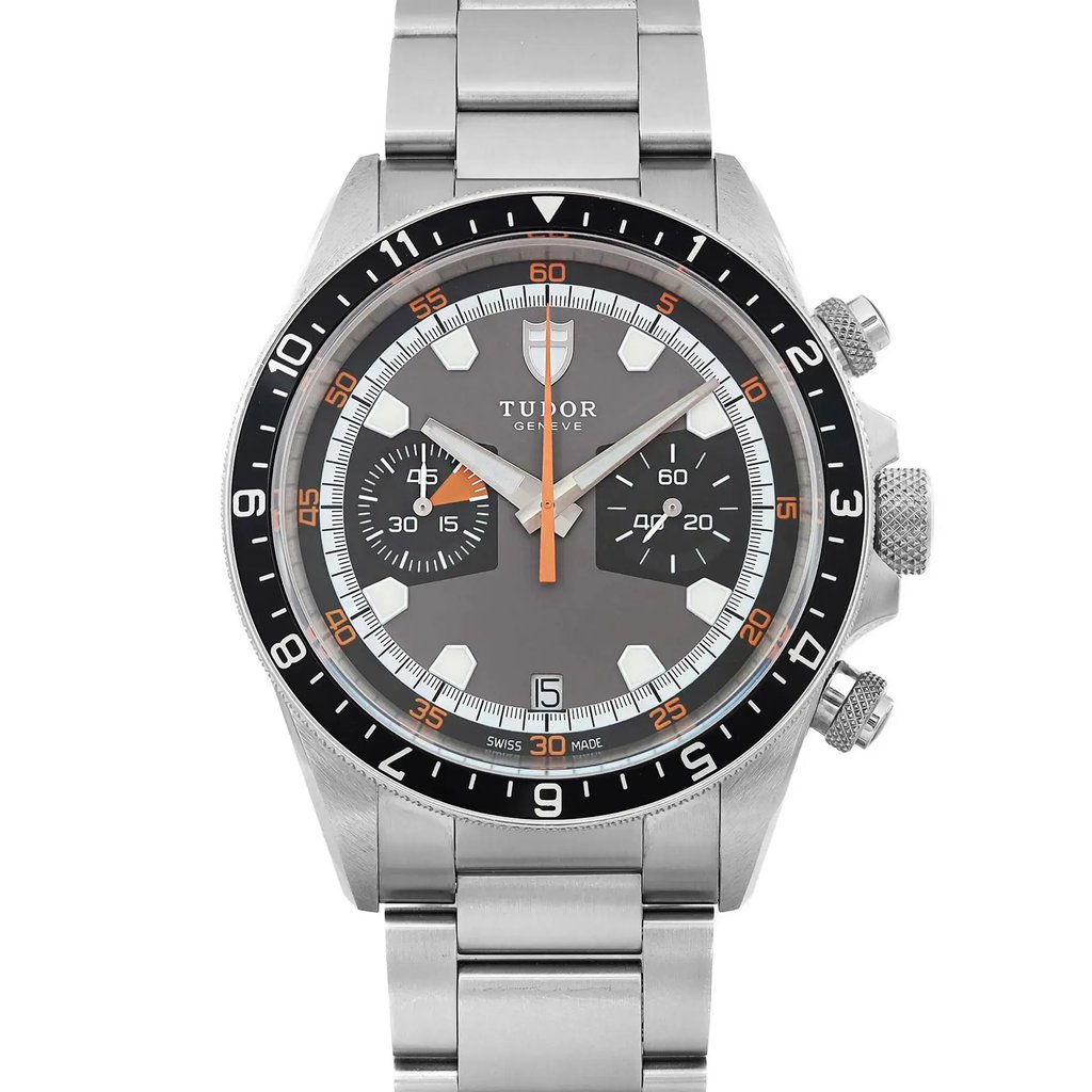 An image of a wristwatch shown in a front close-up shot, focusing on the watch face. The watch is a display model with a metallic bracelet and features a detailed dial with two subdials, bold hour markers, and orange accents. The brand name is visible below the 12 o'clock position. The watch has a sleek, polished design with textured buttons on the side.