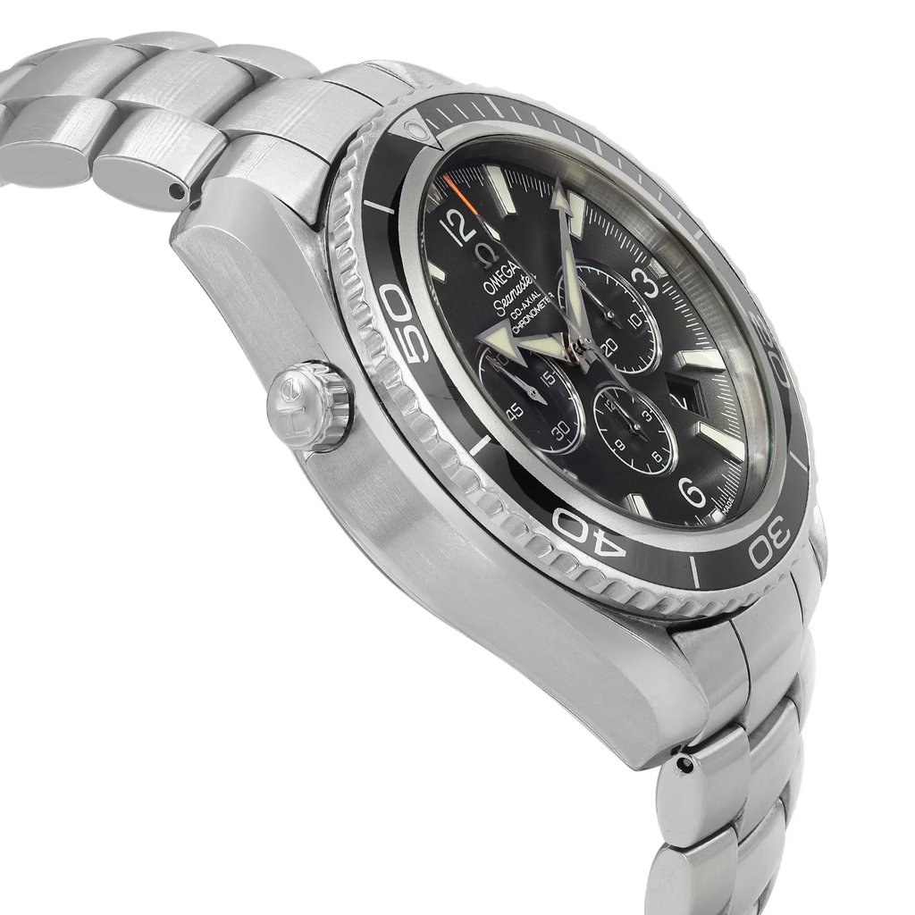 An image of a pre-owned men's OMEGA wristwatch taken from a side angle, showcasing the stainless steel case and bracelet. The watch features a black dial with chronograph sub-dials, a date indicator, and luminous hands. The bezel has engraved numbers, and the crown is visible on the left side. The image is taken at a close distance, highlighting the details of the watch's design and features.
