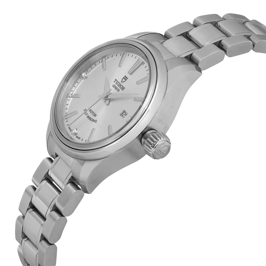 An image of a wristwatch taken from a side profile view, showcasing the crown prominently on the right side. The watch is unworn, and the angle highlights the smooth curvature of the case and the linked metal bracelet. The distance from the watch allows for clear visibility of the dial and the brand logo.