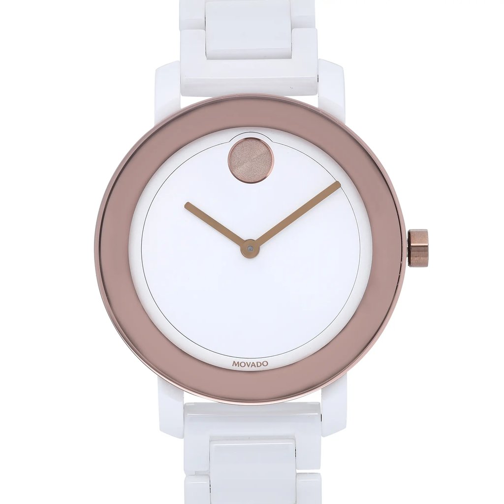 An image of a wristwatch taken from a front close-up angle, focusing on the watch face. The watch features a minimalist design with a white face, gold-tone hands, and a rose gold-tone circular case. The condition is noted as "New With Defects." The white band is partially visible, and the watch crown is positioned on the right side.