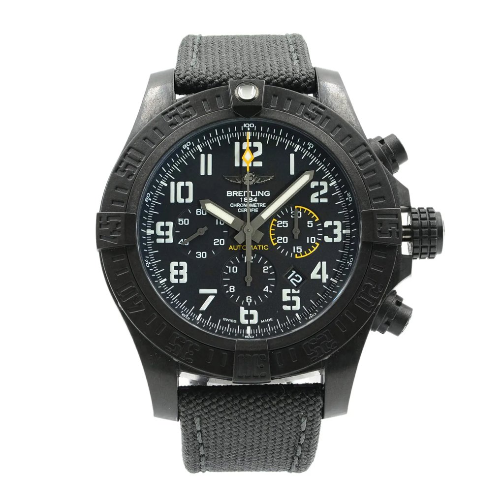 An image of a wristwatch taken from a front full frontal view. The watch is a display model with a black dial featuring white numerals and hands, and additional sub-dials. The case is dark-colored with textured details, and the band appears to be fabric. The image is captured at eye level, providing a clear, direct view of the watch face and strap.