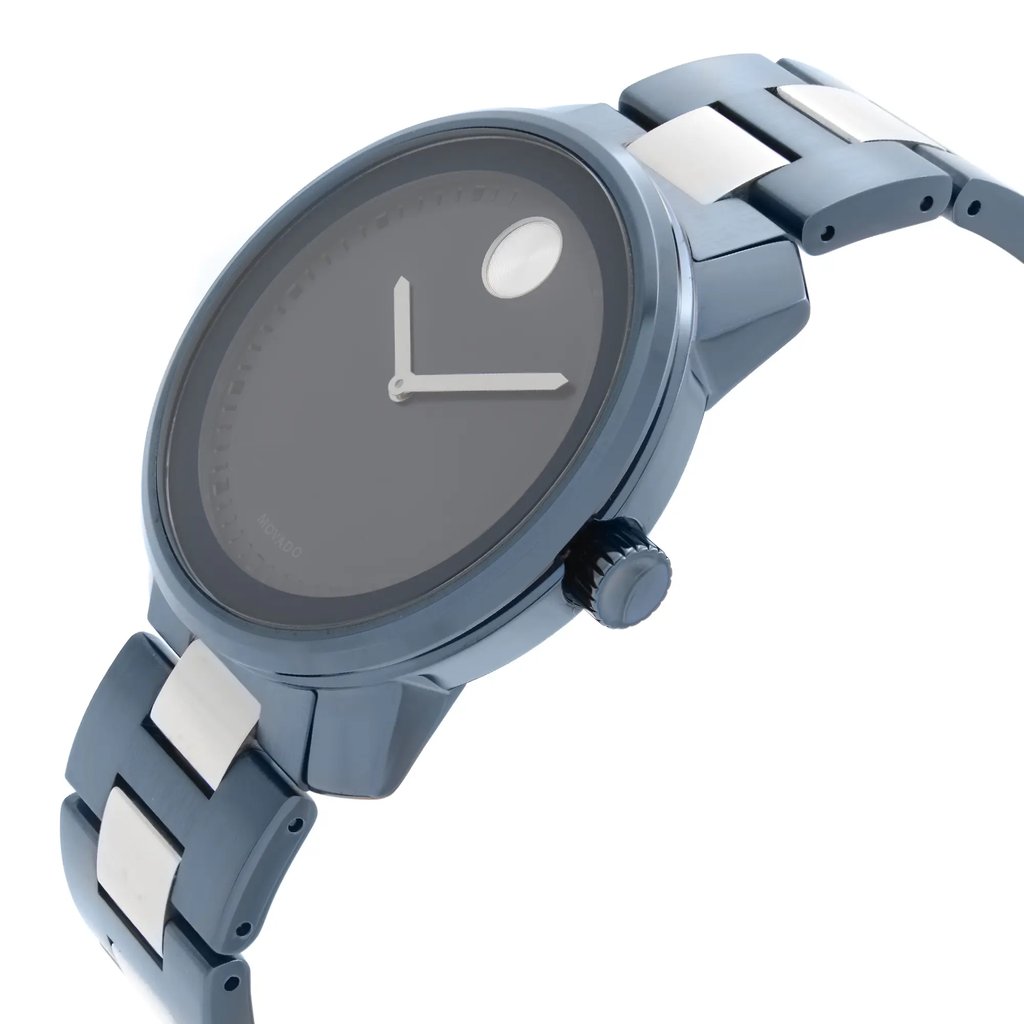 An image of a wristwatch viewed from a side profile angle, highlighting the crown on the right side. The watch has a sleek design with a metallic band featuring alternating link colors. The face is minimalist, and the watch is in new condition with visible defects. The perspective provides a close-up look, emphasizing the detailing on the band and crown.