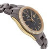 An image of a wristwatch taken from a side profile view, opposite the crown. The watch displays a sleek design with a dark-toned linked bracelet. The face is adorned with a gold-tone bezel encrusted with small, sparkling stones. The dial is black with gold hour markers and hands. The photo captures the watch from an angle that highlights its elegant contours and luxurious detailing, taken at a close distance to emphasize its craftsmanship. The condition is pristine, as it is a display model.