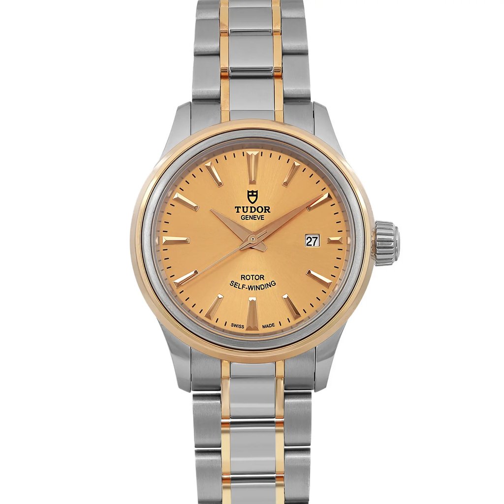 An image of a wristwatch shown in a front close-up view, highlighting the watch face. The watch features a gold and silver two-tone design with a round, gold-toned dial. The hour markers and hands are also gold-toned, and a date window is visible at the 3 o'clock position. The unworn watch has a polished and sophisticated appearance, with a stainless steel bracelet accented by gold links.