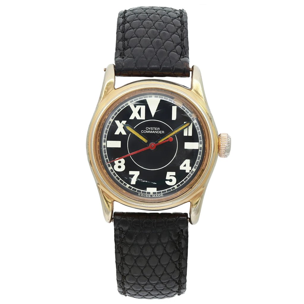 An image of a pre-owned women's Vintage Rolex Oyster Commander Steel Black Dial Ladies Watch 3478, positioned upright and centered at eye level. The watch features a black dial with bold white numerals and a red second hand. It has a gold-tone casing and a textured black leather strap. The view is straight-on, capturing the watch face and strap detail from a close distance.