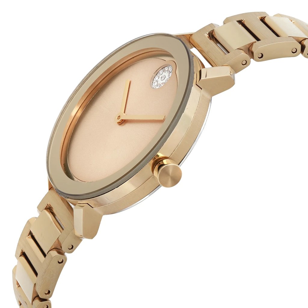 An image of a pre-owned wristwatch displayed from a side profile view, highlighting the crown. The watch features a gold-tone bracelet and a minimalist dial with slender hands. The angle showcases the watch's thickness and detailing, captured from a close distance.