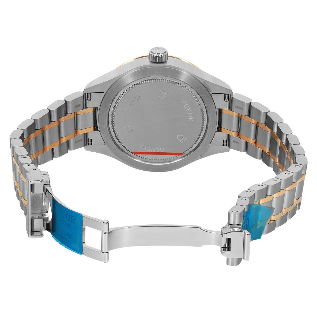 An image of an unworn wristwatch viewed from the back, showing the open clasp. The watch is positioned at a slight angle, highlighting the metallic links of the strap. The image is taken from a close distance, focusing on the intricate details of the clasp and the brushed finish of the watch back.