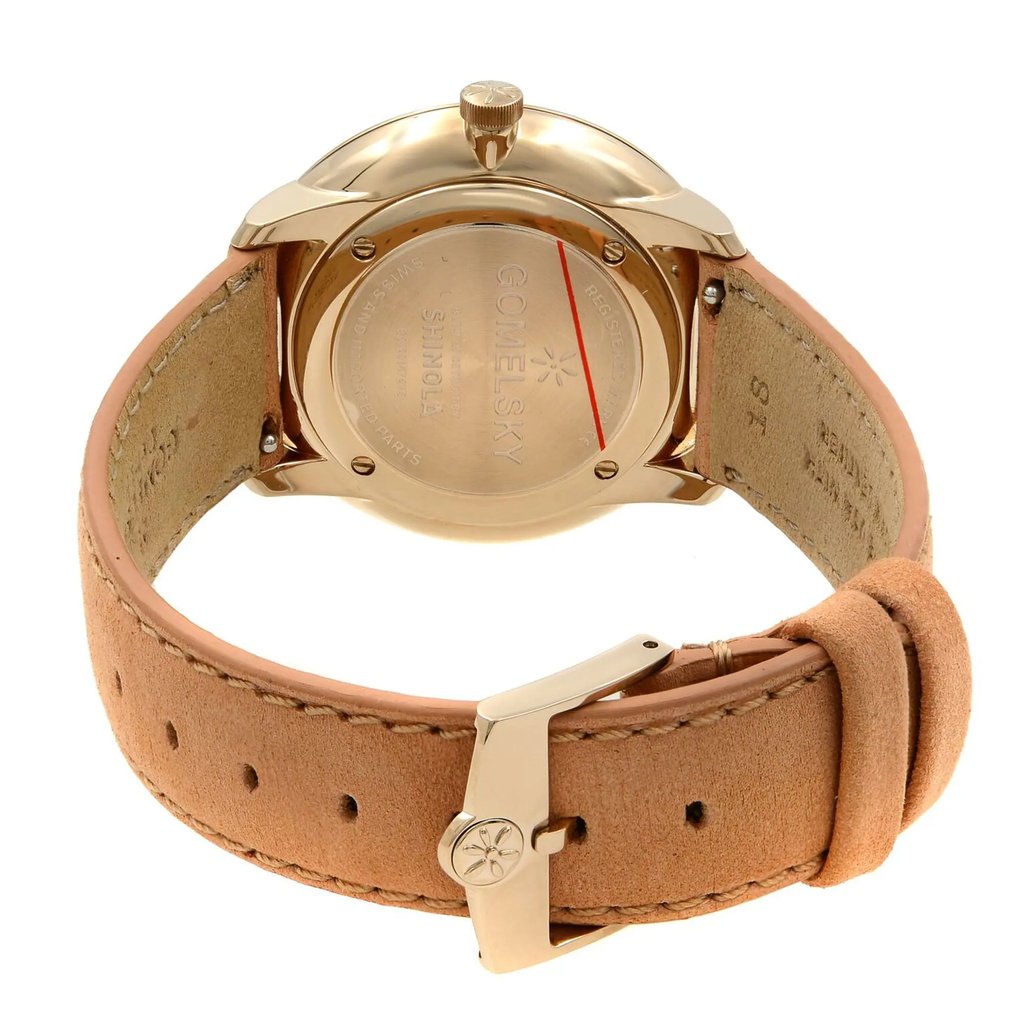 An image of a wristwatch from the back view, showcasing the closed clasp. The watch is unworn and features a gold-toned case back with engraved branding details. The leather strap is light brown and neatly stitched, and the clasp is positioned centrally. The angle is slightly elevated, providing a clear and detailed close-up of the watch's back and clasp.