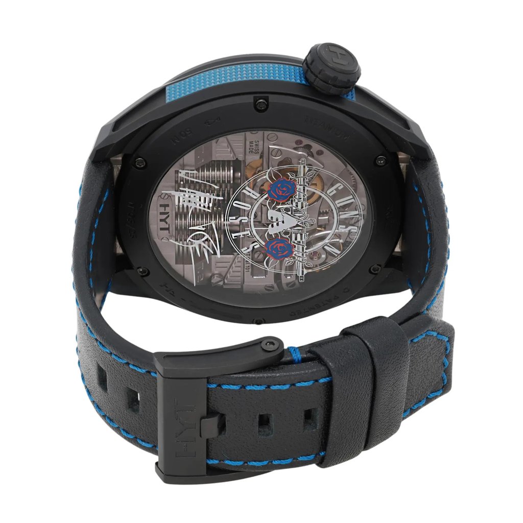 An image of a pre-owned men's HYT Skull AXL Guns N Roses 51mm Titanium PVD wristwatch, viewed from a slightly elevated angle focusing on the back of the watch. The watch features a transparent case back revealing intricate mechanical details, including gears and springs. The case is black with a prominent crown on the right side. The black leather strap has blue stitching, and the buckle is visible in the foreground. The shot is taken from a close distance, highlighting the craftsmanship and design elements.