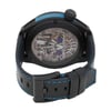 An image of a pre-owned men's HYT Skull AXL Guns N Roses 51mm Titanium PVD wristwatch, viewed from a slightly elevated angle focusing on the back of the watch. The watch features a transparent case back revealing intricate mechanical details, including gears and springs. The case is black with a prominent crown on the right side. The black leather strap has blue stitching, and the buckle is visible in the foreground. The shot is taken from a close distance, highlighting the craftsmanship and design elements.