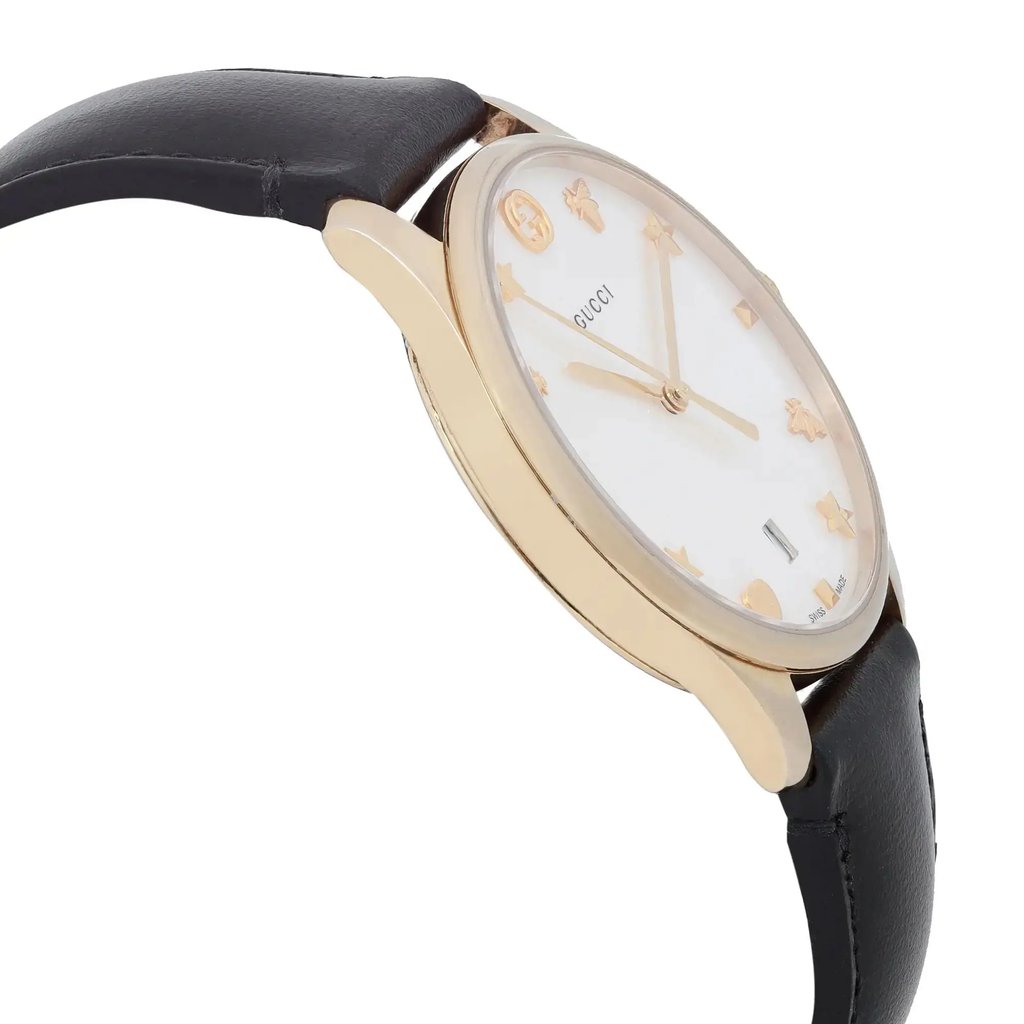 An image of a pre-owned Gucci wristwatch for women, showcasing a side profile view opposite of the crown. The watch features a round shape and a white mother-of-pearl dial with a date indicator. It has a gold bezel and a black leather band. The stainless steel case is visible on the side, and the watch is positioned at a close distance with a clear focus on the side profile, emphasizing the sleek design and formal style of the timepiece.