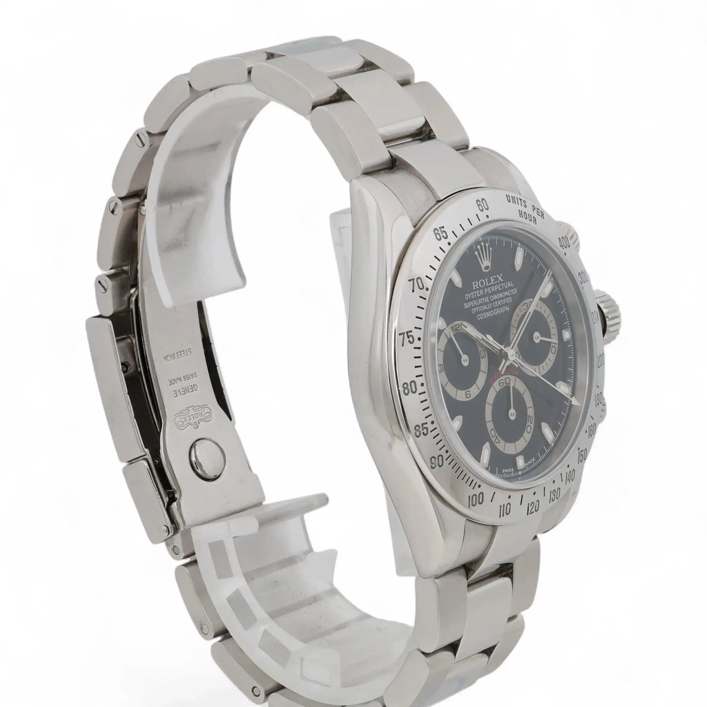 An image of a pre-owned men's Rolex wristwatch positioned at a slight angle, showcasing its side profile. The watch features a silver metal bracelet and a dark dial with chronograph functions, including luminous hands and a small seconds subdial. The watch is photographed close-up, highlighting its intricate details and craftsmanship.