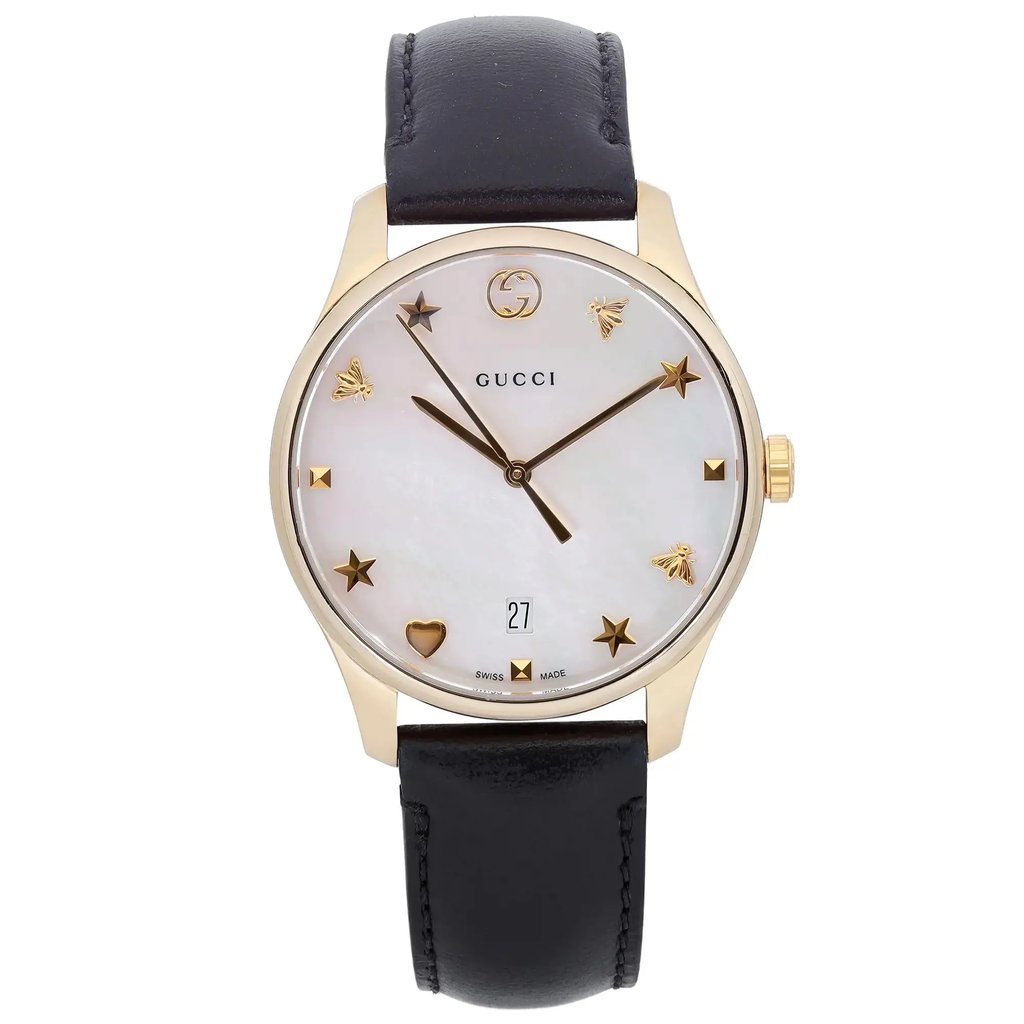 An image of a pre-owned Gucci women's wristwatch in good condition, presented in a front full frontal view. The watch features a round stainless steel case, a gold bezel, and a white mother of pearl dial accented with charm hour marks and a date indicator at the 6 o'clock position. It has a leather band and the photo is taken at a close distance, showing the watch head-on, with the band partially visible, looping downwards.