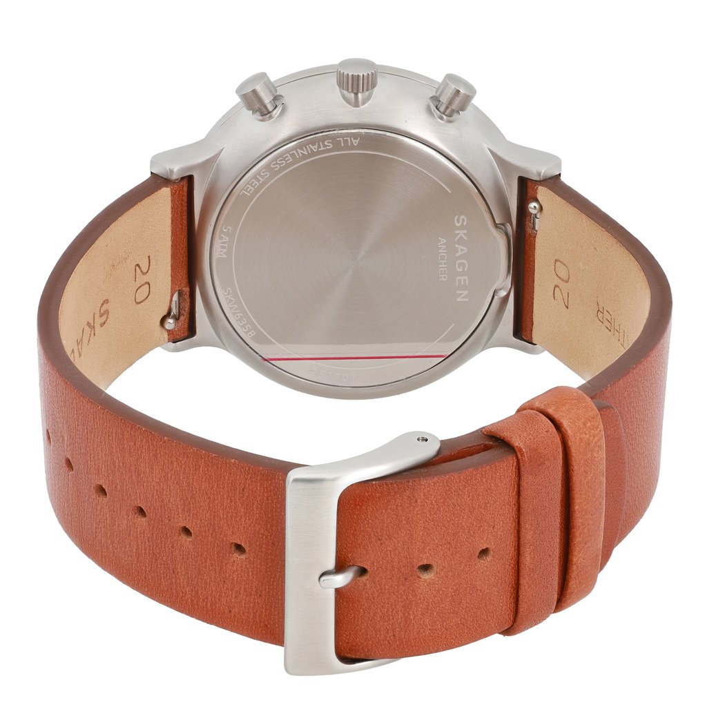 An image of a Skagen men's wristwatch, displayed from the back at a slight angle, showcasing the stainless steel case and detailing. The watch features a chronograph and date indicator. The brown leather strap is prominently shown, with the buckle and adjustment holes visible in the foreground, emphasizing its craftsmanship.