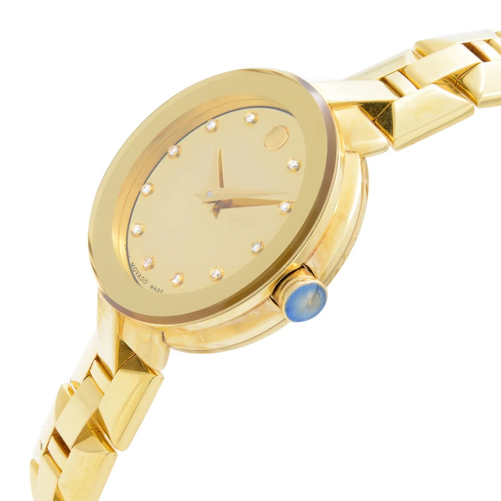 An image of a wristwatch in a side profile view, showcasing its gold finish and elegant design. The crown is prominently visible on the right side of the watch case. The watch features a round face with minimalistic hour markers. The bracelet is also gold, complementing the overall luxurious appearance. The angle captures the watch slightly from above, highlighting its sleek contours and craftsmanship.
