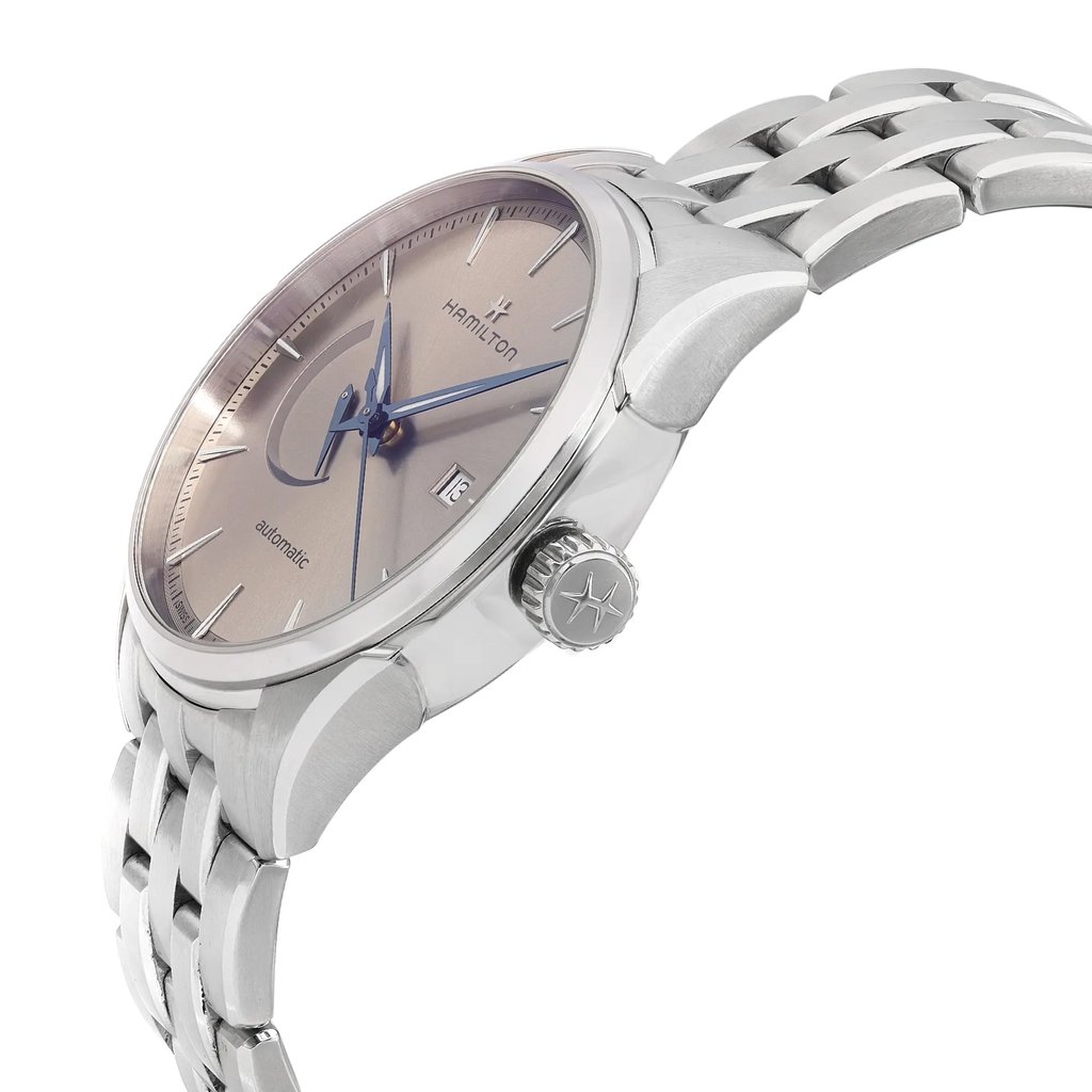 An image of a pre-owned wristwatch captured from a side profile view, prominently displaying the crown. The watch features a metallic bracelet and a sleek, polished case. The angle highlights the watch face and the crown's detailing. The photograph is taken at a close distance, providing a clear view of the watch's features.