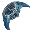 An image of a pre-owned wristwatch shown from a side profile view, highlighting the crown and side buttons. The watch features a blue strap and casing with a detailed dial, emphasizing its intricate design. The angle provides a close-up perspective, showcasing the texture and craftsmanship of the watch.