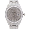 An image of a pre-owned wristwatch showing a close-up, front view of the watch face. The watch features a circular bezel adorned with diamonds, a textured dial displaying the day at the top and the date at the three o'clock position. The hands and hour markers are elegantly designed, and the watch has a polished metal band. The image focuses on the details and craftsmanship of the watch, highlighting its luxurious design.