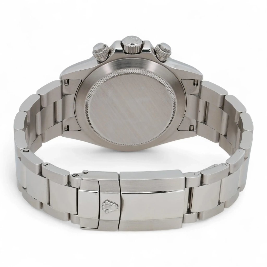 An image of a pre-owned men's Rolex wristwatch taken from a rear angle. The focus is on the stainless steel back case and bracelet, with the watch positioned horizontally. The clasp, engraved with the brand's logo, is prominently visible in the foreground. The crown and pushers are visible on the right side of the case, highlighting the chronograph feature. The image is taken at close range, showcasing the watch’s sleek and polished finish.