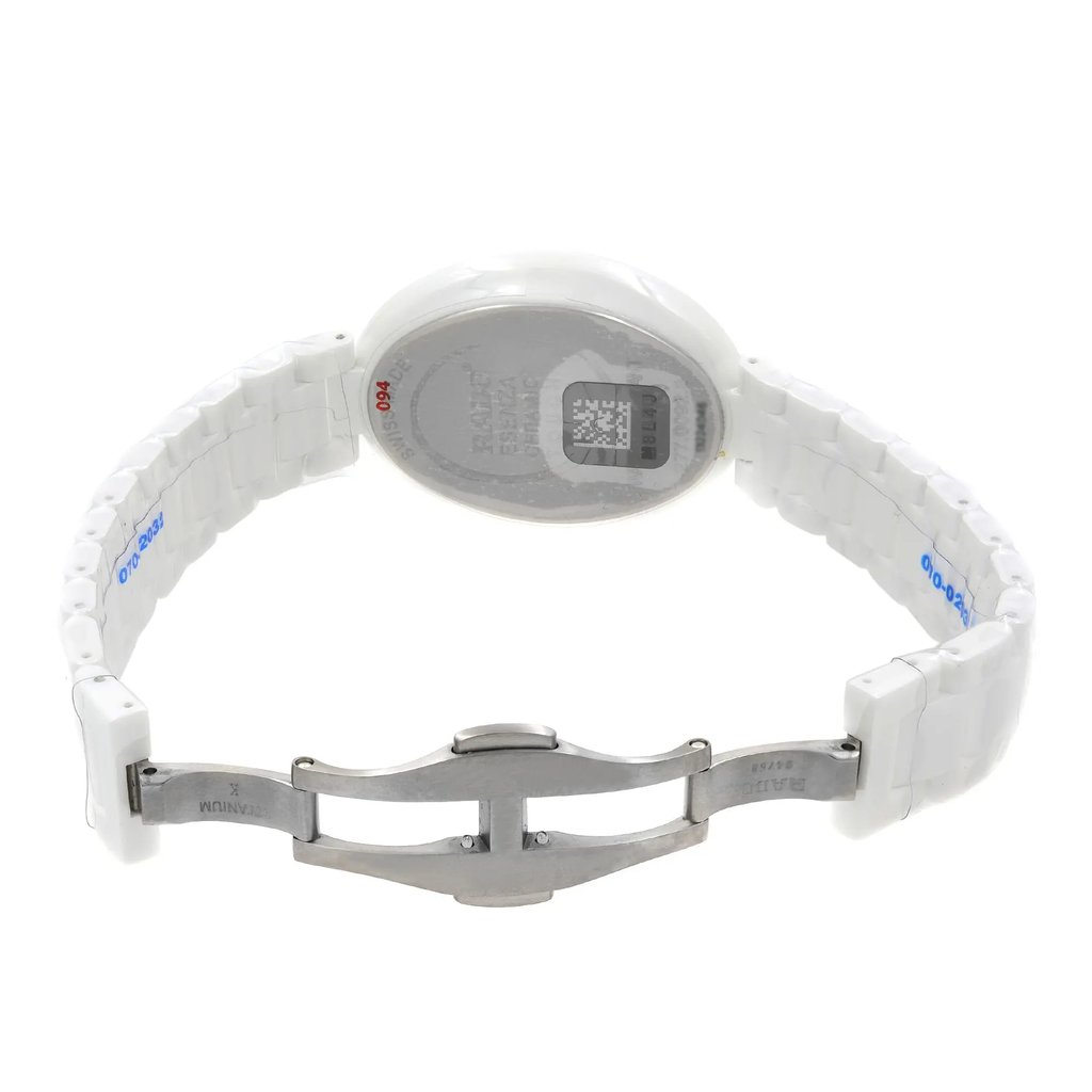 An image of a wristwatch taken from the back view, showing the open clasp. The watch features a white ceramic bracelet with a metallic clasp. The angle captures the watch from a slightly elevated perspective, showcasing the back case and the open clasp mechanism. The image is taken from a close distance, highlighting the details and condition of the display model.