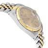 An image of a pre-owned wristwatch captured from a side profile view, opposite the crown. The watch features a two-tone metal bracelet with a combination of silver and gold links. The dial is a light color, encased in a gold bezel, and the angle highlights the watch's elegant design and craftsmanship. The image is taken at a close distance, showcasing the details of the watch face and bracelet.