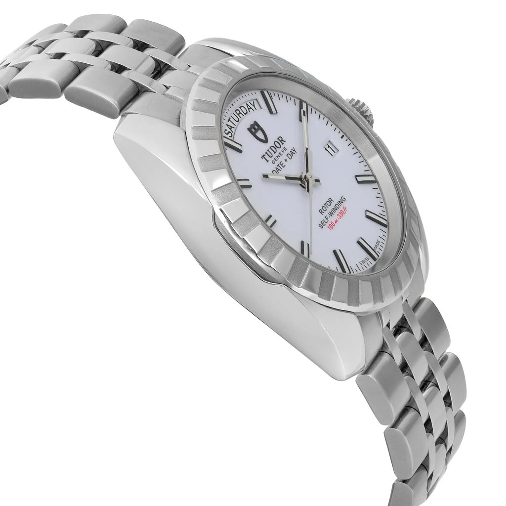 An image of a pre-owned men's Tudor wristwatch displaying its side profile from a slightly elevated angle. The watch features a stainless steel bracelet and a round, fluted bezel. The white dial includes day and date functions, with luminous hands and black hour markers. The watch is photographed at a close distance, highlighting its sleek design and craftsmanship.