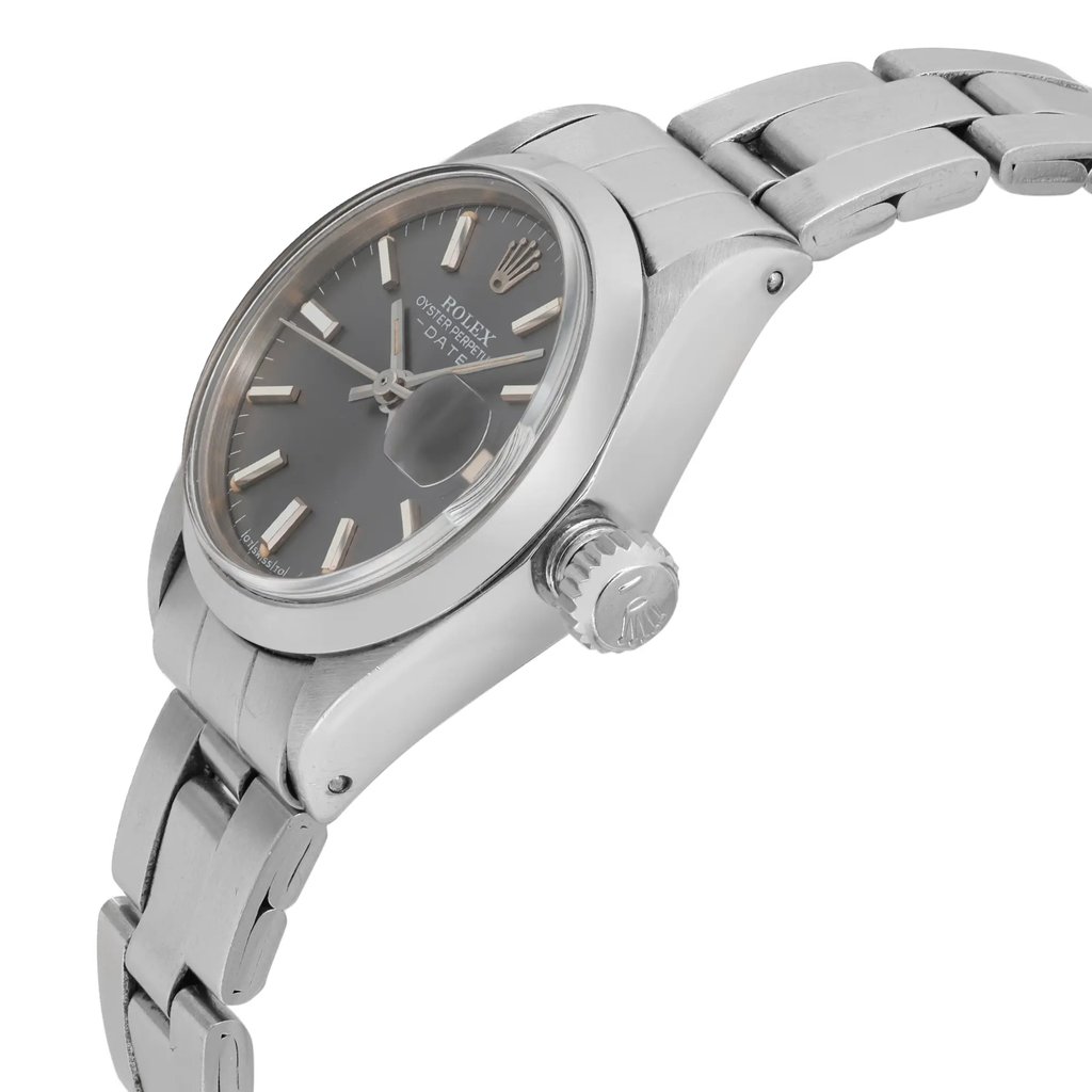 An image of a pre-owned wristwatch shown from a side profile view, highlighting the crown. The watch features a silver metal bracelet and a gray dial with a date function. The angle emphasizes the watch's thickness and the crown's detailed design, captured at a medium distance.