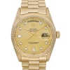 An image of a pre-owned Rolex men's wristwatch in good condition with a front close-up shot focusing on the watch face. The watch features a round case and band made of yellow gold. It has a sunburst gold dial with a day/date display at the 12 and 3 o'clock positions, respectively. The bezel color matches the case and dial, and the indices are stick-style with a 12-hour dial and a seconds hand. Luminous hands are present for improved visibility in low light. Light scratches may be present on the case and bracelet due to age.