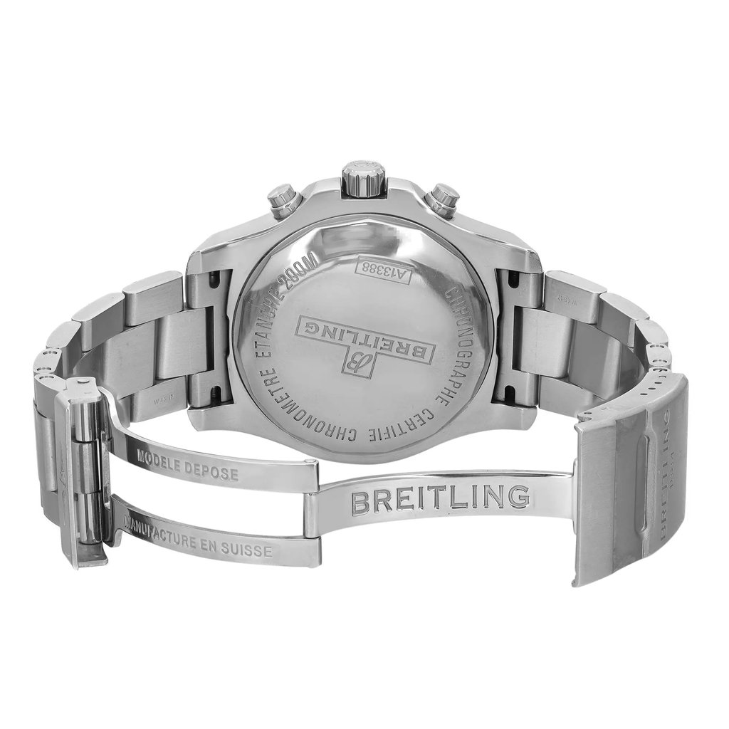 An image of a pre-owned wristwatch, shown from the back view. The focus is on the close-up of the clasp, which is open, revealing engraved text. The watch is positioned to highlight the metal bracelet and the case back, which is prominently marked with brand details. The angle captures the watch at eye level, providing a clear view of the craftsmanship and metallic finish.