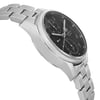 An image of a pre-owned TAG Heuer men's wristwatch in a casual style, presented in a side profile view opposite of the crown. The watch features a round stainless steel case with a gray bezel and a stainless steel band. It has a black dial with chronograph functions, a date indicator, and a small seconds subdial. The angle shows the curvature of the bezel and the links of the bracelet, with a focus on the watch's side, giving a sense of its depth and design. The image is a close-up, showing detail while suggesting minor blemishes from handling and shipping may be present.