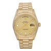 An image of a pre-owned Rolex men's wristwatch in good condition, presented in a full frontal view. The luxury watch features a round yellow gold case and bracelet with visible light scratches due to age. It has a gold sunburst dial with stick indexes and a day/date display at the 12 and 3 o'clock positions respectively. The bezel is also gold, and the watch showcases luminous hands and a 12-hour dial with a seconds hand. The piece is positioned centrally and captured from a close, straight-on angle to clearly show the watch's details and design.