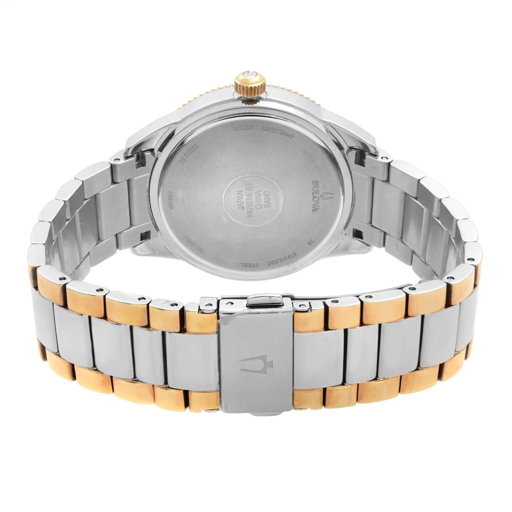 An image of a Bulova women's wristwatch featuring a stainless steel caseback and a two-tone stainless steel band with gold accents. The watch is displayed with the back of the case facing upwards and the fold-over clasp with double push buttons is closed, positioned in the center. The watch is photographed from a top-down angle, providing a clear view of the snap caseback and the brand name inscribed on it. The round shape of the watch is evident, and the condition appears to be a display model with no visible wear. The image is taken from a close distance, showcasing the details of the watch's design and construction.