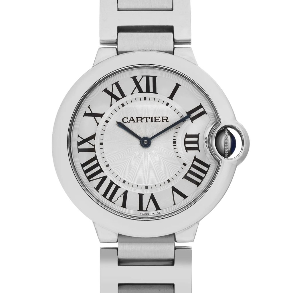 An image of a pre-owned Cartier unisex wristwatch in good condition, featuring a close-up front view of the silvered guilloché dial with black Roman numerals and blue hands, set within a round stainless steel case with a steel bezel. The watch has a 12-hour dial and is attached to a stainless steel band. The crown is visible on the right side of the case, with a blue accent. The Cartier logo is prominently displayed at the top of the dial. The shot is taken from a direct, front-facing angle and at a close distance, focusing on the watch face and upper part of the band.