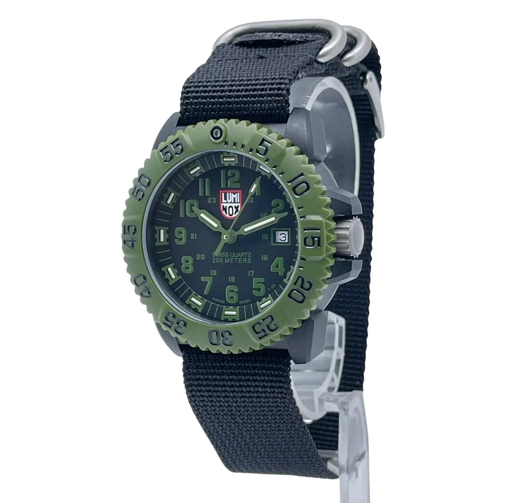 An image of a Wristwatch by Luminox. This Pre Owned item is designed for Men, featuring a Casual,Diver style. It has a Quartz movement and an Analog display with a Black dial color. The indices include 12-Hour Dial,Arabic Numerals. The band is made of Nylon and the case is made of Carbon. The watch has a Round shape with a case size of 44 mm and a case thickness of 15 mm.