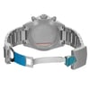 An image of a wristwatch seen from the back, with the clasp open. The angle showcases the watch's case back and the links of its metal bracelet. The photograph is taken at a close distance, highlighting the intricate details and the brushed metal finish. The watch appears to be a display model, with protective blue stickers visible on parts of the clasp.